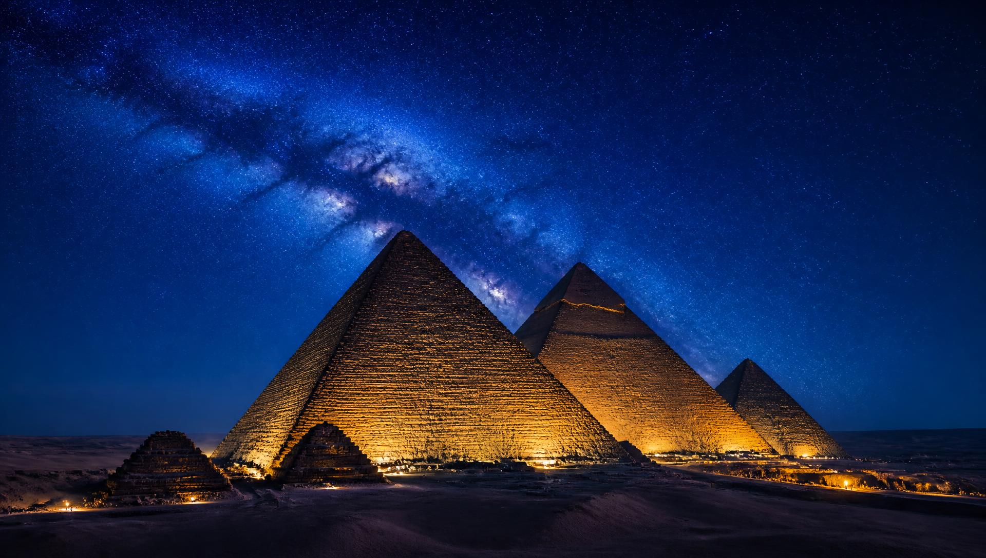 Pyramids at night beneath the stars with golden lights